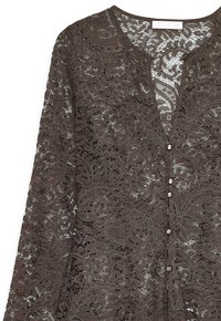 Blusa in pizzo marrone con motivi floreali, scollatura a V, maniche lunghe e chiusura a bottoni con bottoni metallici rotondi.