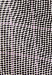 Tessuto con un motivo a scacchi bianco e nero, caratterizzato da sottili linee viola che creano un effetto a griglia. Il tessuto ha una texture liscia.