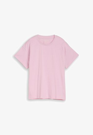 Prosty, jasnoróżowy, oversize'owy bawełniany T-shirt z krótkim rękawem i okrągłym dekoltem, położony płasko na białym tle.