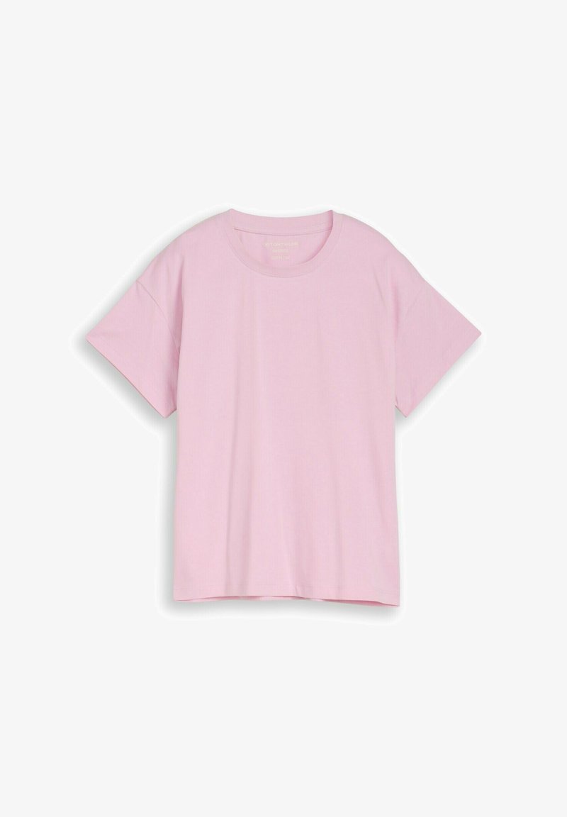 T-shirt en coton rose clair uni, oversize, manches courtes, col rond, posé à plat sur fond blanc.