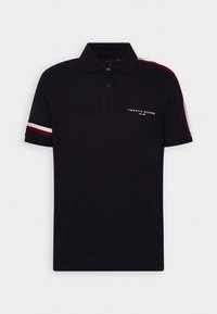 Polo noir à manches courtes avec patte à deux boutons, rayures rouges et blanches sur les manches et les épaules, et petit logo Tommy Hilfiger sur la poitrine.