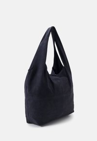 Dark navy suede tote bag with a soft texture, featuring a rounded shape and two elongated shoulder straps. Minimalist design with no visible hardware.