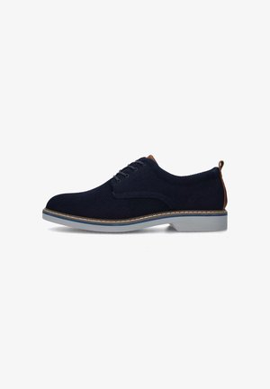 Scarpe stringate in maglia blu navy con una parte superiore texturizzata, dettagli in pelle color tan e una suola in gomma grigio chiaro con un bordo cucito.