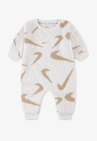 Weißer Fleece-Overall mit beigen Nike-Logo-Mustern, gerippten Bündchen und rundem Hals. Weicher Stoff und lockere Passform, geeignet für Säuglinge.