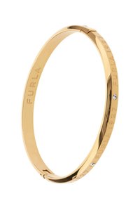Kuldtooniga metallist bangle-käevõru, millel on graveeritud "FURLA 1927" tekst ja väike kristallektsent lisatud detailina. Sile, läikiv viimistlus.