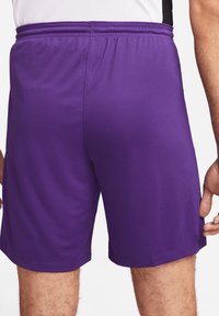 Shorts de sport violets en tissu léger et lisse. Dotés d'une taille élastique et d'une coupe décontractée, ils sont taillés au-dessus du genou.