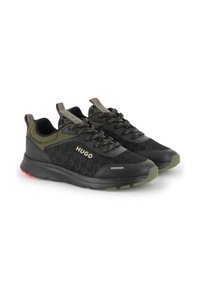 Czarne i oliwkowo zielone sportowe sneakersy z teksturowanymi podeszwami, wzorzystymi uchwytami, sznurówkami oraz logo "HUGO" na boku.