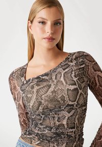 Top a maniche lunghe con un motivo a stampa serpente in tonalità di marrone e beige, con un design a spalla unica e dettagli arricciati sul lato.
