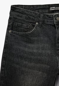 Czarne proste dżinsy wykonane z denimu, charakteryzujące się klasycznym pięciopocketowym designem, widocznym szwem i metalowym zapięciem.