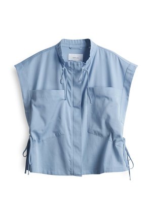 Top senza maniche blu chiaro con colletto alto, due taschini frontali, chiusura con cordino e lacci laterali regolabili per una vestibilità personalizzabile.
