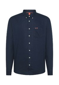 Camicia blu navy con bottoni e maniche lunghe, dotata di una tasca a toppa e un piccolo logo rosso sul petto. Realizzata in tessuto intrecciato.