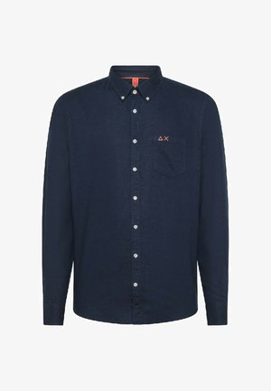 Camicia blu navy con bottoni e maniche lunghe, dotata di una tasca a toppa e un piccolo logo rosso sul petto. Realizzata in tessuto intrecciato.