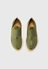 Grüne, leichte Sneakers mit Mesh-Obermaterial, elastischem Riemen über dem Vorderfuß und leichter Sohle. Mit einem pinken Zugband an der Ferse.