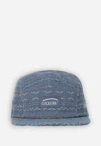 Casquette bleu foncé avec un motif texturé, visière plate, et un patch rectangulaire du logo Oxbow à l'avant. Le matériau semble en tissu.
