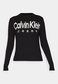 Pull en maille noire avec un col rond et des manches longues. Présente un logo blanc prononcé "Calvin Klein Jeans" sur le devant. Ourlets côtelés.
