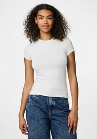Hvid kortærmet t-shirt med rund halsudskæring, tætsiddende design og glat tekstur, parret med blå højderede denim jeans.
