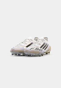 White and grey soccer cleats featuring black accents, textured design, and contrasting patterns. Equipped with prominent studs for traction.