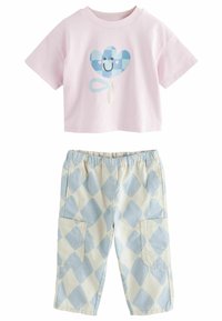Camiseta corta rosa con un gráfico de corazón a cuadros en azul. Pantalones crema con un patrón de diamantes en azul claro y dos bolsillos laterales.