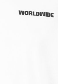 White cotton t-shirt featuring the text "WORLDWIDE" in bold black font, positioned diagonally on the front. Smooth texture.