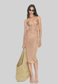 Knee-length fitted dress in metallic rose gold with thin straps, featuring cut-out details and paired with a large glittery gold bag.