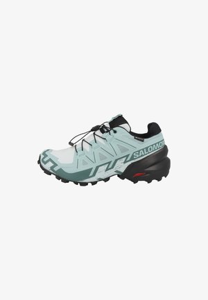 Trail running shoe featuring a mint green and black design, with a textured upper, lacing system, and a rugged sole for grip.