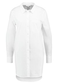 Witte overhemd met lange mouwen, kraagontwerp, enkele linkerkijdenzak, gemaakt van een gladde stof, iets gebogen zoom, minimalistische stijl.