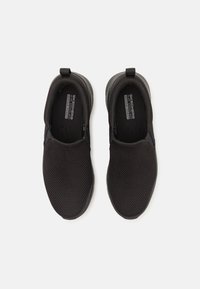 Zapatos negros sin cordones con parte superior de malla transpirable, collar acolchado y suela texturizada. Presenta agujeros de ventilación y un diseño ligero.