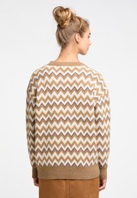 Pulover cu model zigzag în nuanțe de maron și crem, cu o croială lejeră, manșete ribbate și un decolteu clasic la gât. Textură moale, grosime medie.