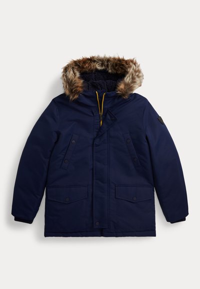 Parka azul marino con capucha con borde de piel, cierre de cremallera en la parte frontal, cuatro bolsillos delanteros y puños de canalé. Material impermeable con una textura suave.