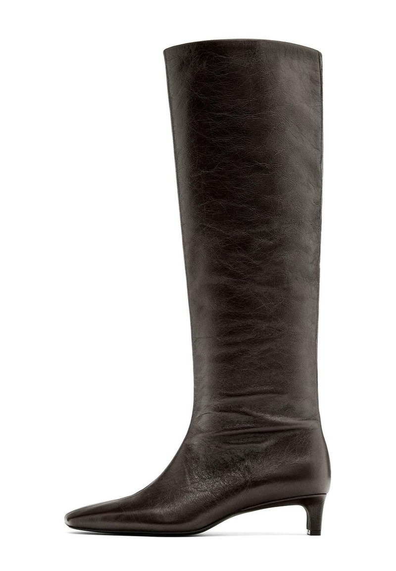 Botte noire en cuir montant jusqu'au genou, avec un bout pointu et un petit talon effilé. Texture lisse avec un effet de plis subtil.