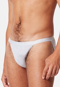 Perizoma da uomo in cotone bianco con un sottile elastico in vita con il logo "SKINNY". Texture liscia, copertura minima e design aderente.