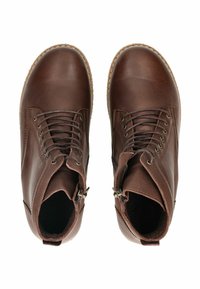 Brązowe skórzane botki za kostkę z sznurówkami, zaokrąglonymi noskami, bocznymi zamkami, teksturowaną cholewką i gumowymi podeszwami. Widoczne szwy i metalowe oczka.