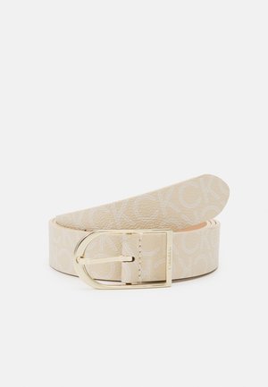 Beige leren riem met herhaald Calvin Klein-logo print en goudkleurige rechthoekige gesp, opgerold en getoond tegen een witte achtergrond.