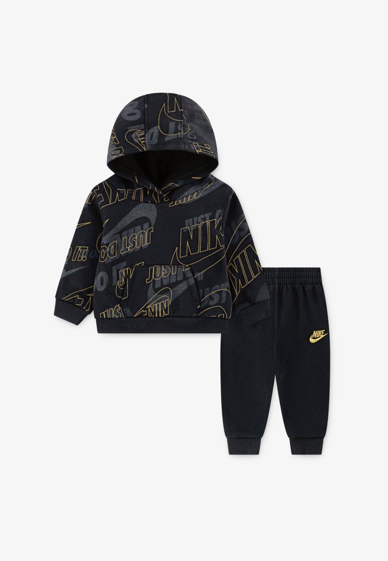 Mustad mustri dressipluus ja püksid, millel on kuldsed "Nike" logo ja loosungid, pehme kangas, tasku ees ja soonikkoes äärised ning vöökoht.