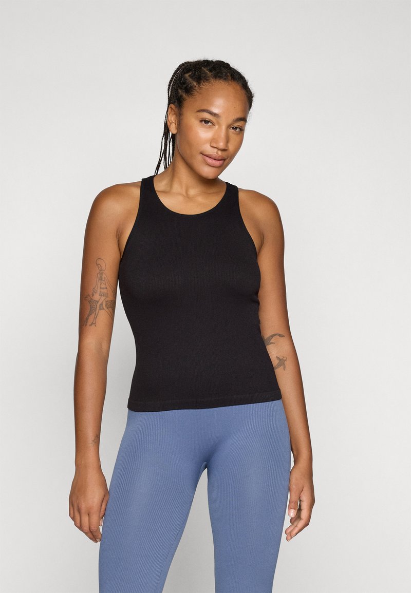 Svart ribbet tanktop med smale stropper, kombinert med lyseblå ribbede leggings. Glatt tekstur og tettsittende design.
