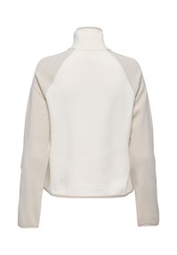 Pull-over en polaire crème et beige avec col montant, manches raglan et texture douce. Présente une coupe décontractée sans éléments métalliques visibles.