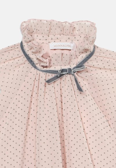 Blouse transparente rose pâle avec de petits pois noirs, col à volants, garniture en velours gris et un nœud gris assorti à l'encolure.
