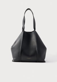 Melnas ādas tote soma ar fakturētu virsmu, trīsstūrveida formu un diviem gariem rokturiem. Apakšējā daļā ir smalks zelta logotips.