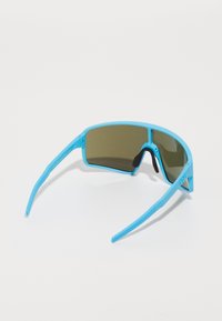 Lunettes de soleil de sport bleues avec un design enveloppant, verres marron et branches texturées. Monture en plastique légère avec une finition mate.