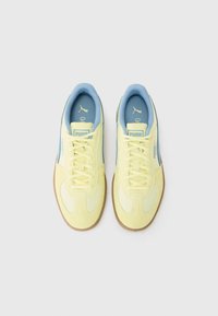 Gule semskede sneakers med lyseblå detaljer, med snørebåndsdesign og teksturerte gummisåler. Merking på hæler og tunger.