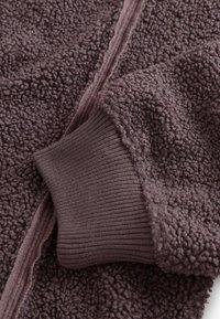 Fleecejacka i mörklila, med en strukturerad yta, ribbade ärmslut och blixtlås fram. Mjukt, fluffigt tyg med en avslappnad design.