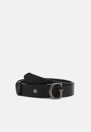 Schwarzer Designergürtel mit strukturiertem Muster und Metall-"G"-Schnalle, graviert mit dem Markennamen Guess, auf weißem Hintergrund gewickelt.
