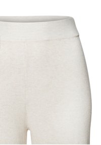 Krémové rebrované legíny s jemnou textúrou, vybavené širokým elastickým pásom a bezšvovým dizajnom, ktoré poskytujú pohodlné nosenie.