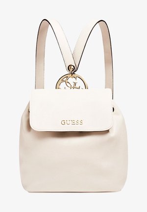 Sac à dos Guess, similicuir beige, forme arrondie, ferrures dorées, fermeture à rabat, bretelles réglables, détail logo sur le devant.