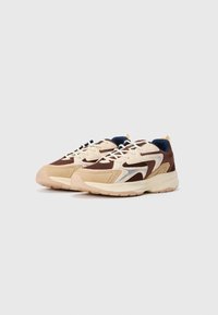 Lave sneakers i beige, brun og marineblå med mesh-paneler, snøring foran og tykke kremfargede såler på en hvit bakgrunn.