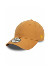Verstellbare Baseballkappe in sandigem Tan, mit runder Krone, gebogenem Schirm und einem kreisförmigen Markenpatch auf der Vorderseite. Gelbe Nähte.