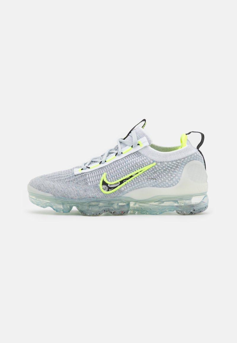 Tenisky Nike Air VaporMax mají šedou pletenou vrchní část s neonově zelenými akcenty a průhlednou vzduchovou odpruženou podrážku. Lehce a prodyšný design.