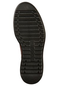 Semelle de chaussure en caoutchouc noir avec des crampons profonds, présentant des crêtes horizontales et verticales pour l'adhérence. Logo central embossé.