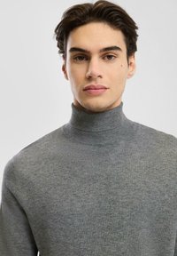 Grijze turtleneck trui van een textuurgebreide stof, met een hoge kraag en een aansluitend ontwerp.