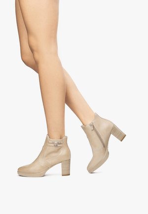 Beige enkellaarsjes van glad leer met een textuur zijpaneel, blokhak en ritssluiting aan de achterkant.